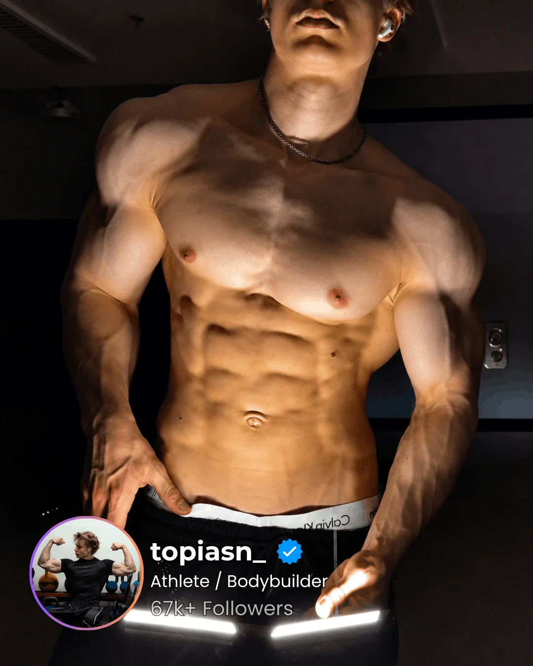 Athlete's torso lit by two GYMLIGHT bars held low, showing vascularity and muscle separation